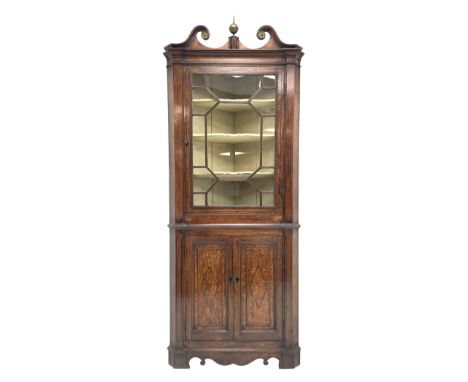 George III oak floor standing corner cabinet, scrolled swan neck pediment with central finial over astragal glazed door, pain