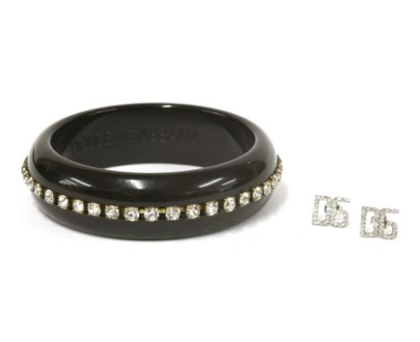 A Dolce and Gabbana black resin bangle, set with white Swarovski crystals to the centre, in dust bag, anda pair of Dolce and 