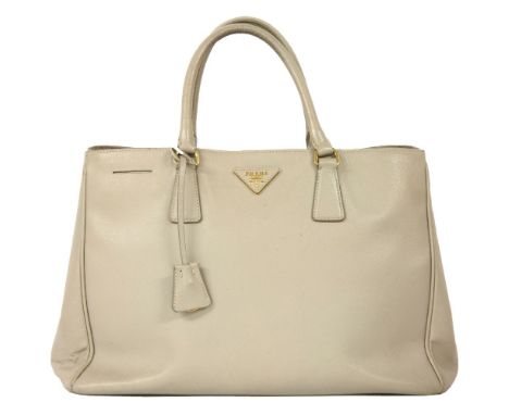 A Prada light grey tote handbag,in saffiano leather, with a triangular maker's name plaque to the front exterior, a detachabl