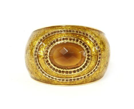 A Roberto Cavalli gold enamel tapering cuff bangle,with a single faceted orange cabochon to the centre surrounded by two rows