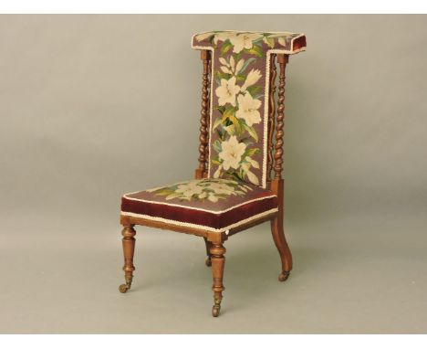 A Victorian walnut prie dieu, with a tapestry back and seat, and twist turned back supports