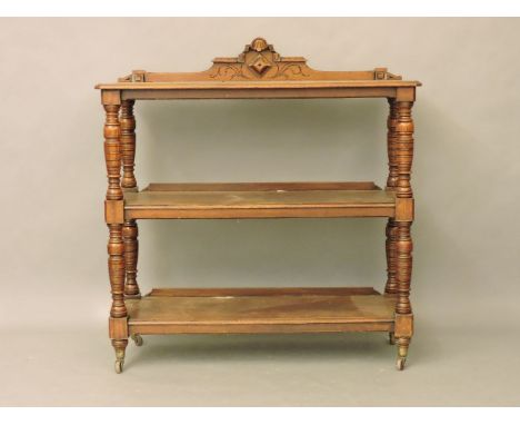 A Victorian three tier buffet with turned supports, on ceramic coasters, 123cm wide