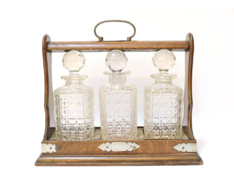 A three bottle oak tantalus, 37cm long