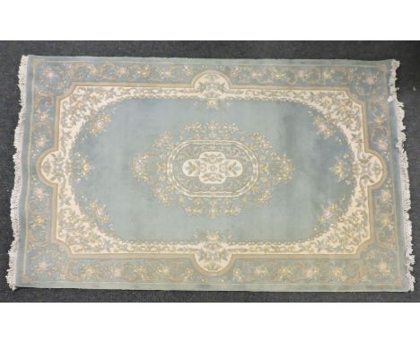 An Oriental blue ground rug, central medallion with a vase of flowers design, 190cm x 133cm, together with a Chinese blue gro