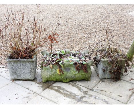 A pair of small square reconstituted stone planters, together with a low rectangular planter with scrolling corners