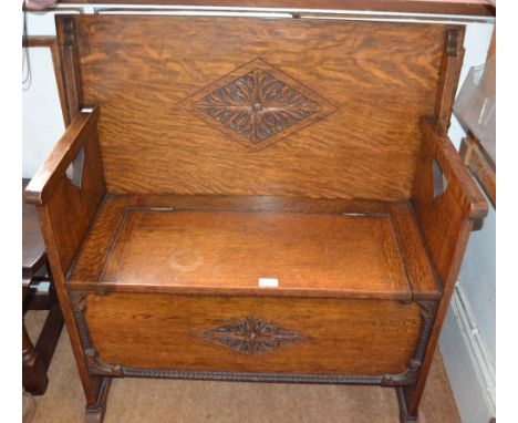 Repro oak finished monk's bench of typical design and construction