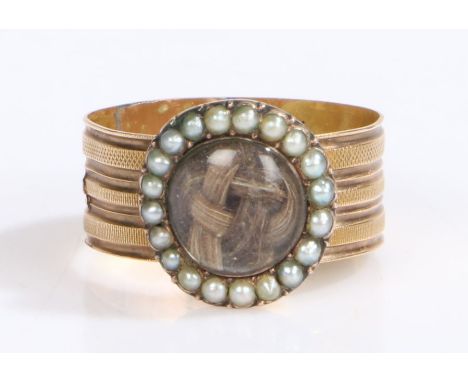 An 18th century yellow metal mourning keepsake ring. Woven hair in a circular casing with surrounding pearls.Ring size P.Engr