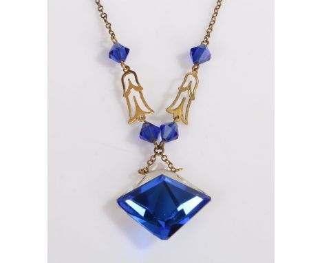 A yellow metal art deco necklace with a faceted clear and blue paste pendant.Weighing 5.50 grams.Used, in very good condition