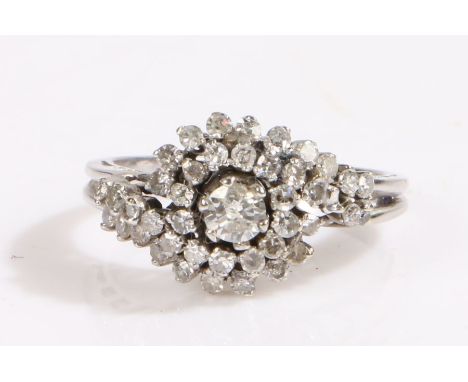 An 18ct white gold diamond halo ring.One central round cut diamond, approx. carat weight 0.25cts. Surrounding halo, total app