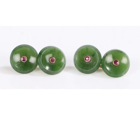 A pair of yellow metal round jade cuff-links set with a ruby in each.Approx. total ruby carat weight: 0.20cts.diameter 12mm.W