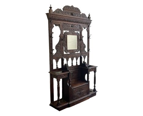 Victorian heavily carved oak hall-stand, moulded cornice with foliate carved decoration over bevelled mirror back, drop centr