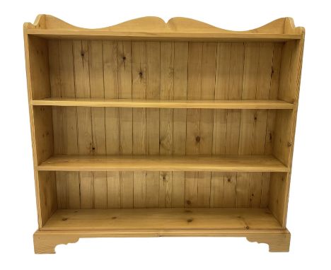 Waxed pine bookcase, shaped pediment over four tiers, on bracket feetDimensions: Height:&nbsp;112cm&nbsp; Length/Width:&nbsp;