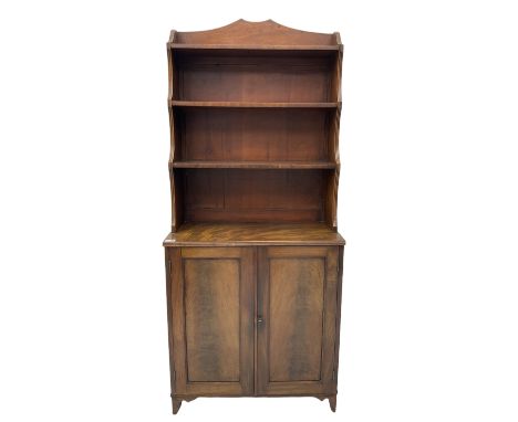 19th century mahogany bookcase on cupboard, raised three tier waterfall bookcase on cupboard enclosed by two panelled doors, 
