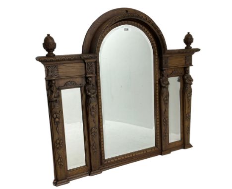 Late 19th century carved oak overmantle mirror, arched top with foliate carved edge and two turned acorn finials, triple beve