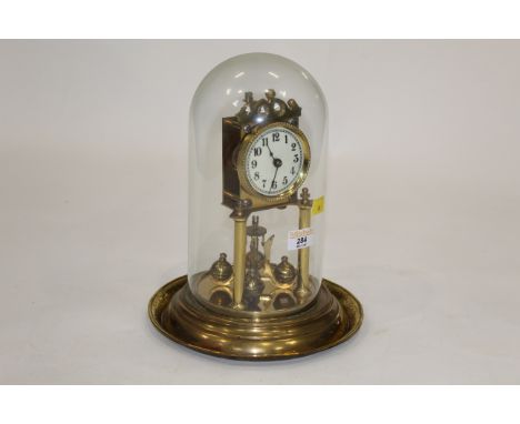 Perpetual motion brass mantle clock with glass dome, height including dome 30 cm