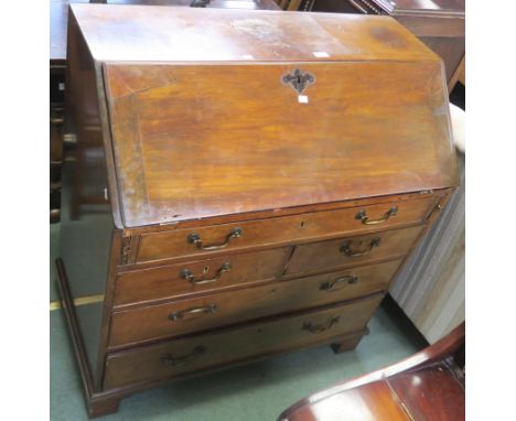 A Georgian mahogany bureau with fitted interior with full width drawer over two smaller drawers then another two drawers on b