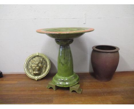 A green glazed terracotta birdbath with inscription, a large brass lion mask door knocker and a French stoneware vaseLocation