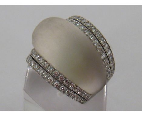 A rock crystal and diamond bombe ring, the ballooned crescent stone between two double rows of pave set brilliants totalling 