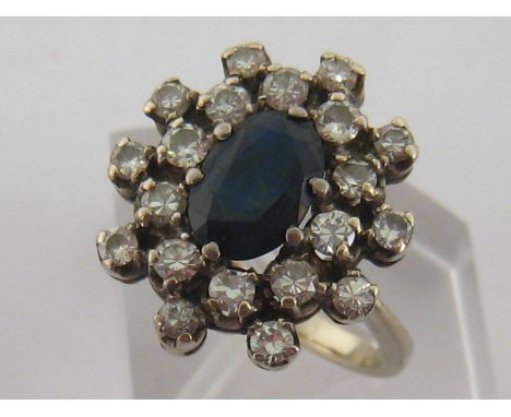 A sapphire and diamond cluster ring, the central oval cut stone 9 x 6.4mm, in a two tiered surround of claw set brilliants, t