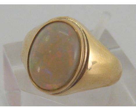 A 14 carat yellow gold and opal ring, the central stone 11 x 8.1 x 2.9 (deep) mm, the shank stamped '585', finger size K, 4.6