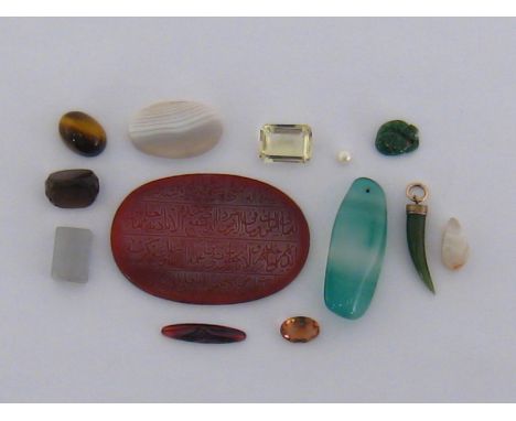 A bag of loose stones, including a carnelian tablet, etched with Arabic script, sardonyx, tiger's eye, jade, smokey quartz an