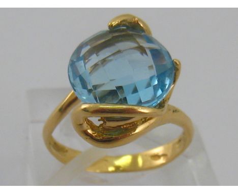 A yellow metal (tests 18 carat gold) blue topaz ring, topaz approx 12mm diameter, ring size M, 5.5 gms. Stone with small nibb