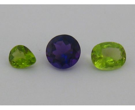 A mixed lot of loose stones, including a round cut amethyst 19 mm diameter x 7.7mm deep, 1.12gms; an oval cut peridot, 12.3 x