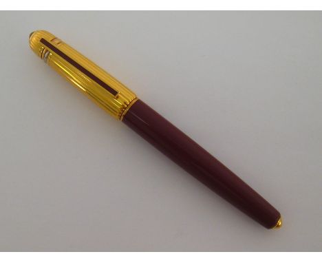 CARTIER. Pasha, a burgundy and rolled gold fine liner pen, no.1988 4492, the signed cap with red jewel and Cartier Trinity ri