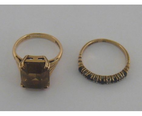 Two 9 carat gold rings, the first set with citrine, finger size J, the second a nine stone sapphire and diamond half hoop rin