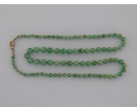 A jade bead necklace, composed of 87 graduated beads, the largest measuring 9.2mm diameter, to a yellow metal (tests as 14 ca