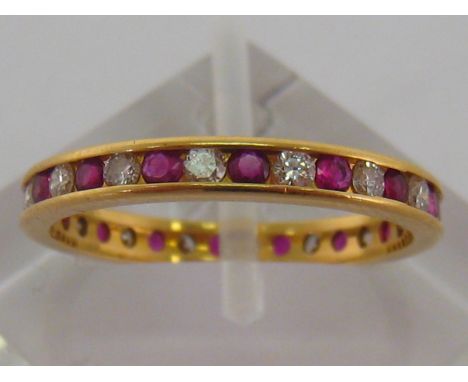 A ruby and diamond eternity ring, alternately set with brilliants and round cut rubies, the band 2mm width, mounted in 18 car