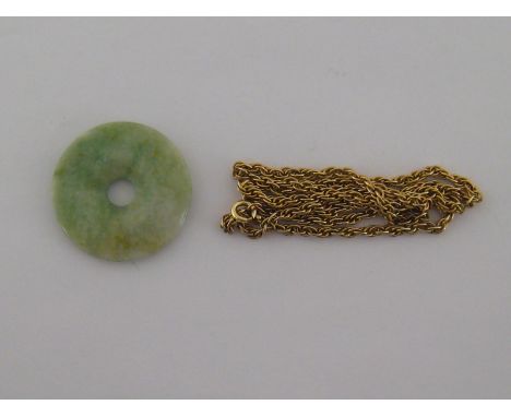 A jade disc pendant, 38mm diameter, on a yellow metal rope link chain, the chain 56cm long
 CONDITION REPORT: chain unmarked
