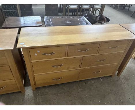 Moder light wood seven drawer chest with metal handles, 137cm wide