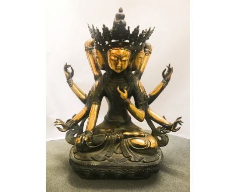 A MONUMENTAL CHINESE PARTIAL GILT METAL FIGURE DEPICTING A THREE-FACED, EIGHT-ARMED BODHISATTVA OF COMPASSION. THE FIGURE IS 