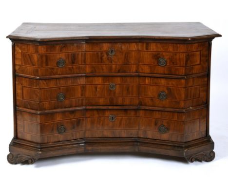 An Italian late 17th century walnut commode chest, of shaped outline, crossbanded, having three long drawers, on scroll carve