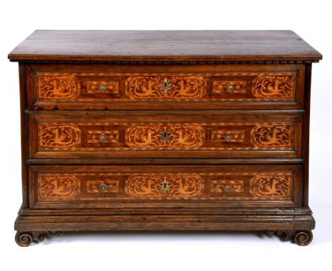 A late 17th century Italian walnut commode chest, of three long drawers, the drawer fronts inlaid with mythical beasts and fo