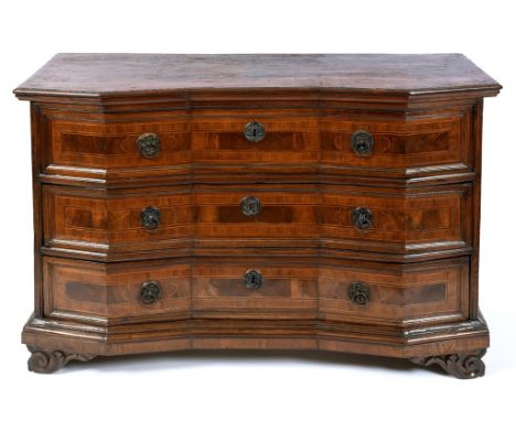 An Italian late 17th century walnut commode chest, of shaped outline, crossbanded, having three long drawers, on scroll carve