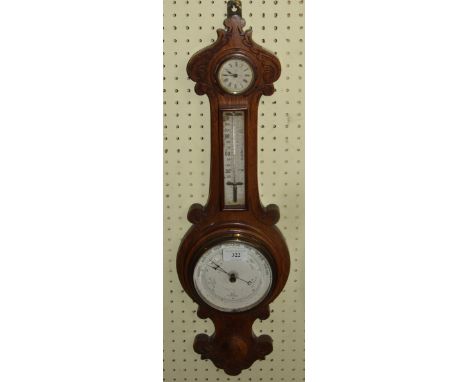 A wall barometer, with a thermometer and a timepiece, in a carved oak case, 62 cm high