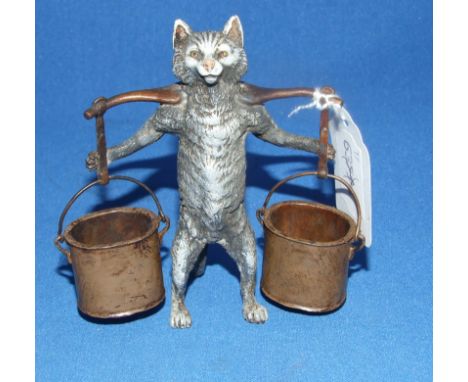 A novelty cold painted cat, carrying a yoke with two buckets, 10.5 cm high Condition report Report by NG

Modern item.  Some 