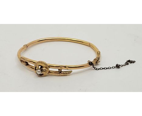 A precious yellow metal and cultured pearl set hinged bangle, (yellow metal assessed as gold). (gross weight 5.1g)