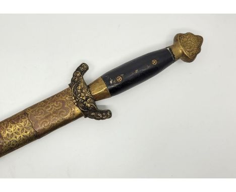 A 20th century Sino-Tibetan ceremonial sword, having 73cm double edged blade, brass hilt and pommel with ebonised grip, in br