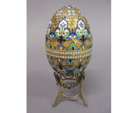 Continental silver, silver gilt and coloured enamel egg form box bearing pseudo Fabergé marks mounted on an associated stand,