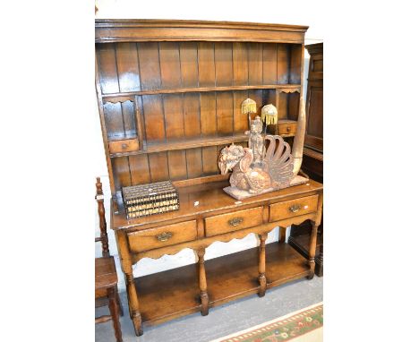 Good quality reproduction oak dresser with a boarded shelf back above three drawers, turned supports and undertier