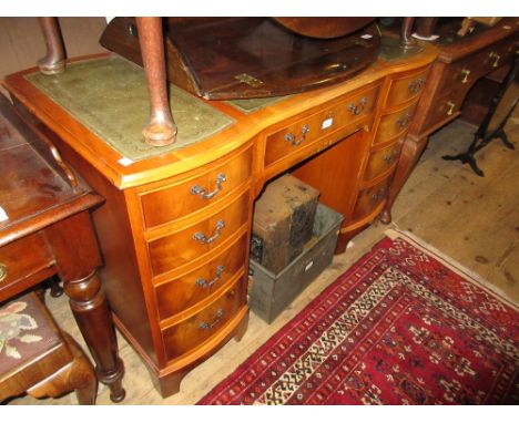 Reproduction yew wood twin pedestal desk with a three section leather inset top above nine drawers on bracket feet