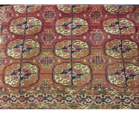 Small Tekke rug with three rows of six gols on a wine ground with borders, 4ft x 3ft 6ins approximately