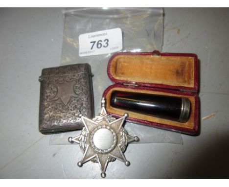 Silver floral engraved vesta case, silver cigarette holder in case and a silver medallion