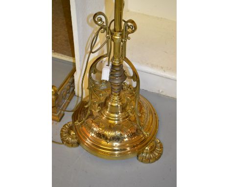 Victorian brass lamp standard with a circular embossed base on stylised shell feet