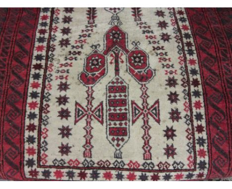 Belouch prayer rug with a stylised design on an ivory ground with multiple red ground borders