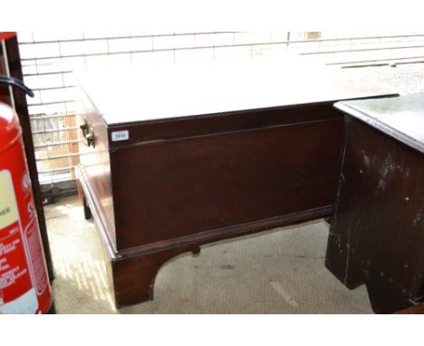George III mahogany trunk, the hinged lid enclosing a void interior raised on bracket feet, 35ins wide with brass end carryin