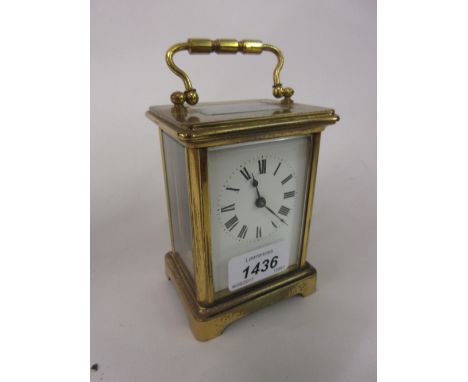 Small brass cased carriage clock with enamel dial, Roman numerals and single train movement in a leather covered travel case